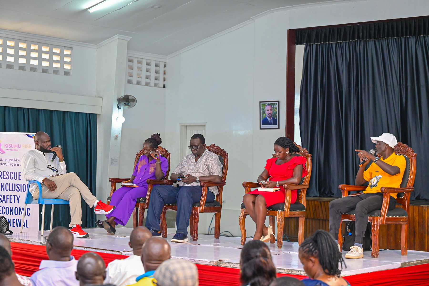 Panelists speaking before the assembled Kisumu audience