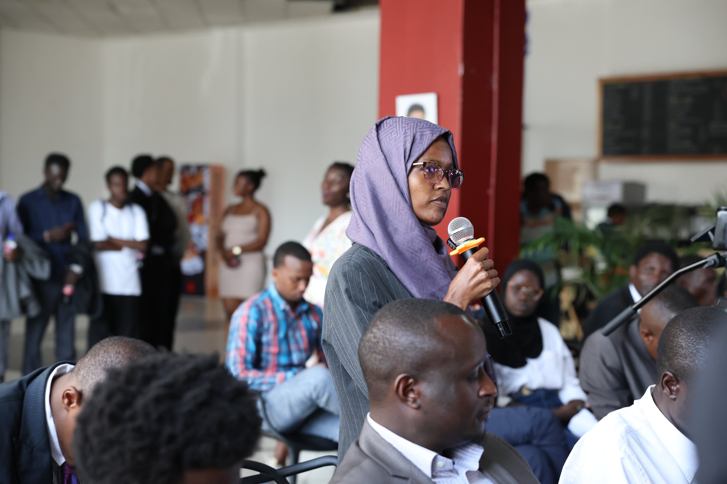 A woman wearing a headscarf asking a question from the audience