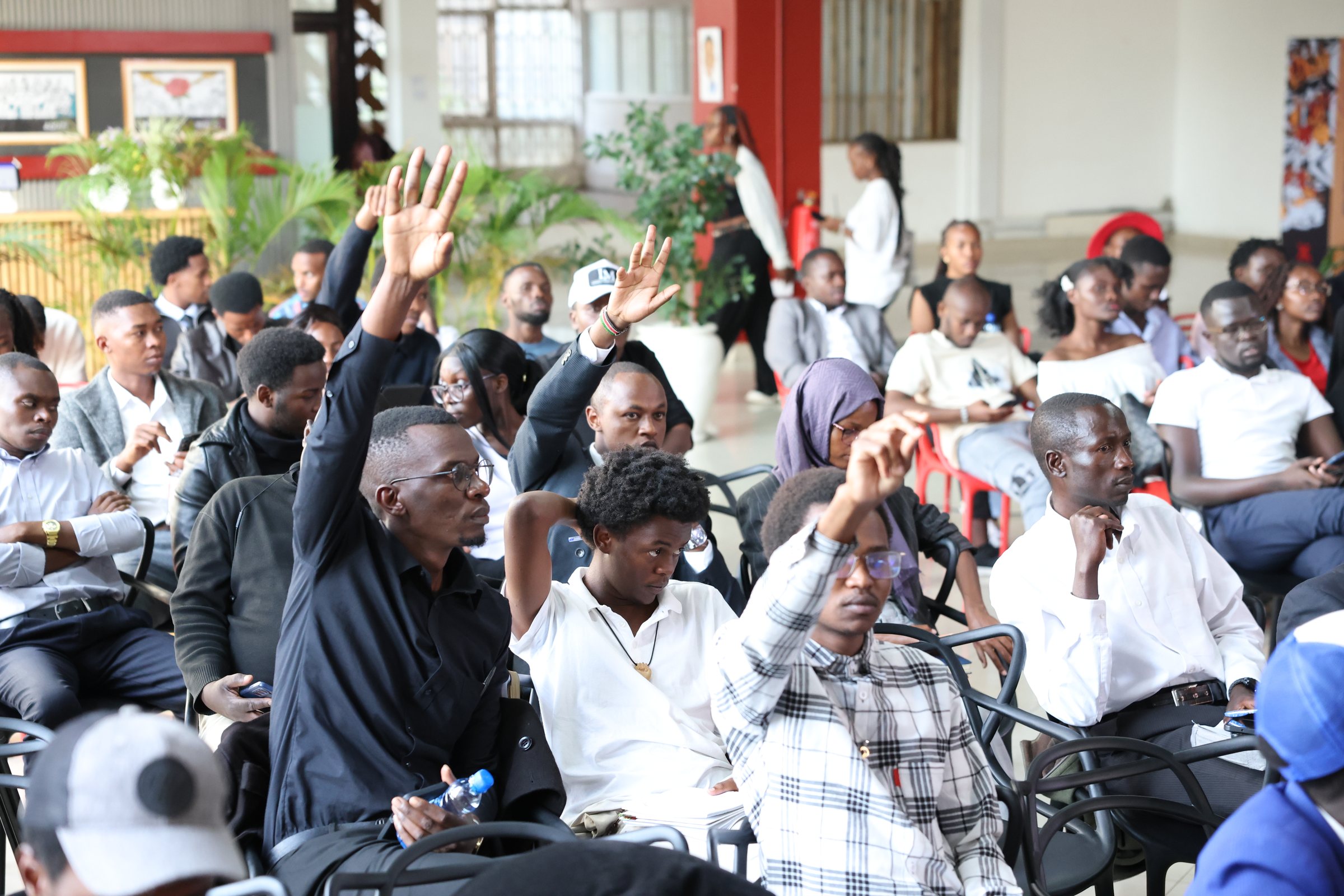 Many audience members raising their hands to participate
