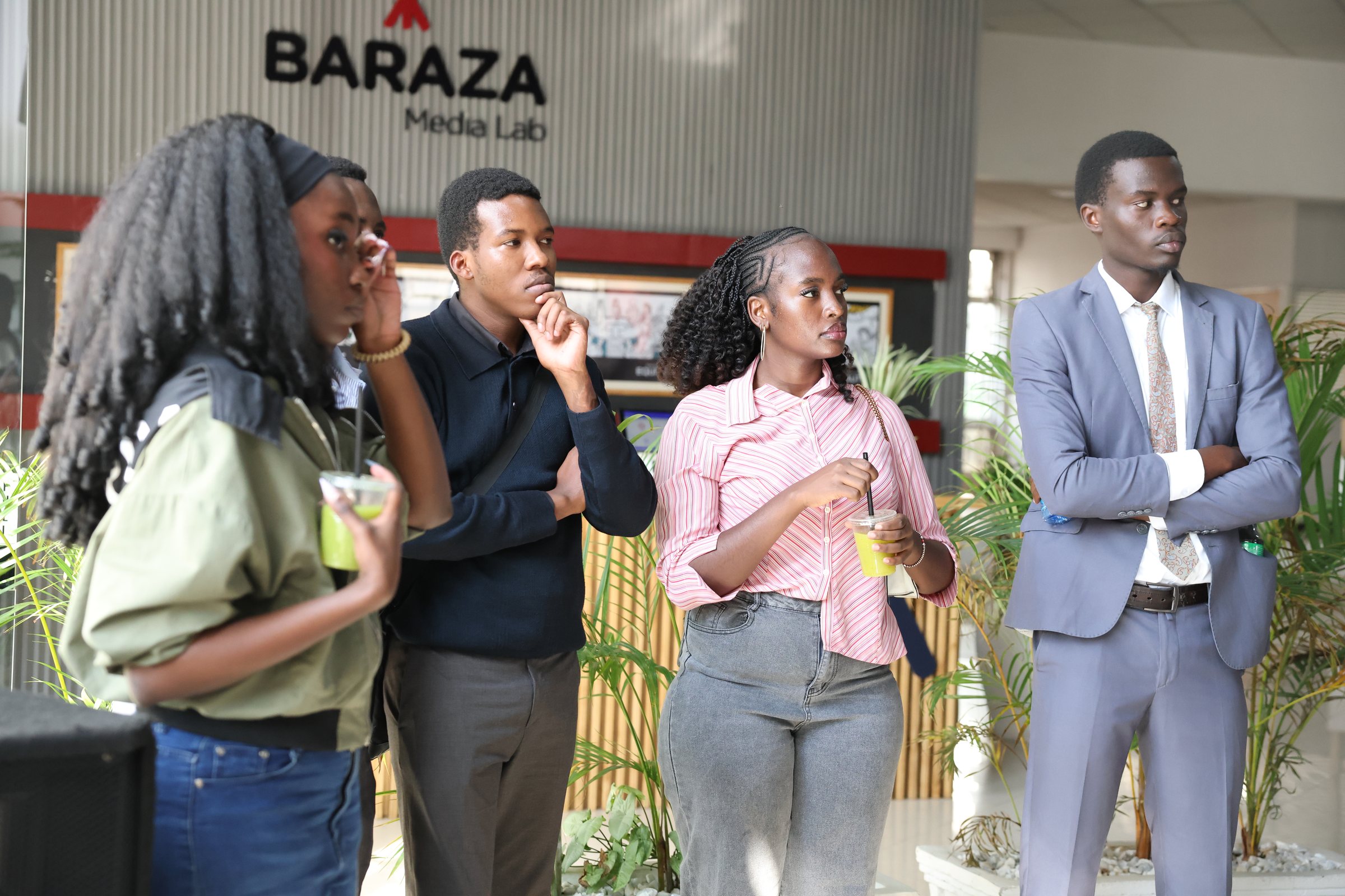 A group of young participants standing beneath the Baraza Media Lab sign