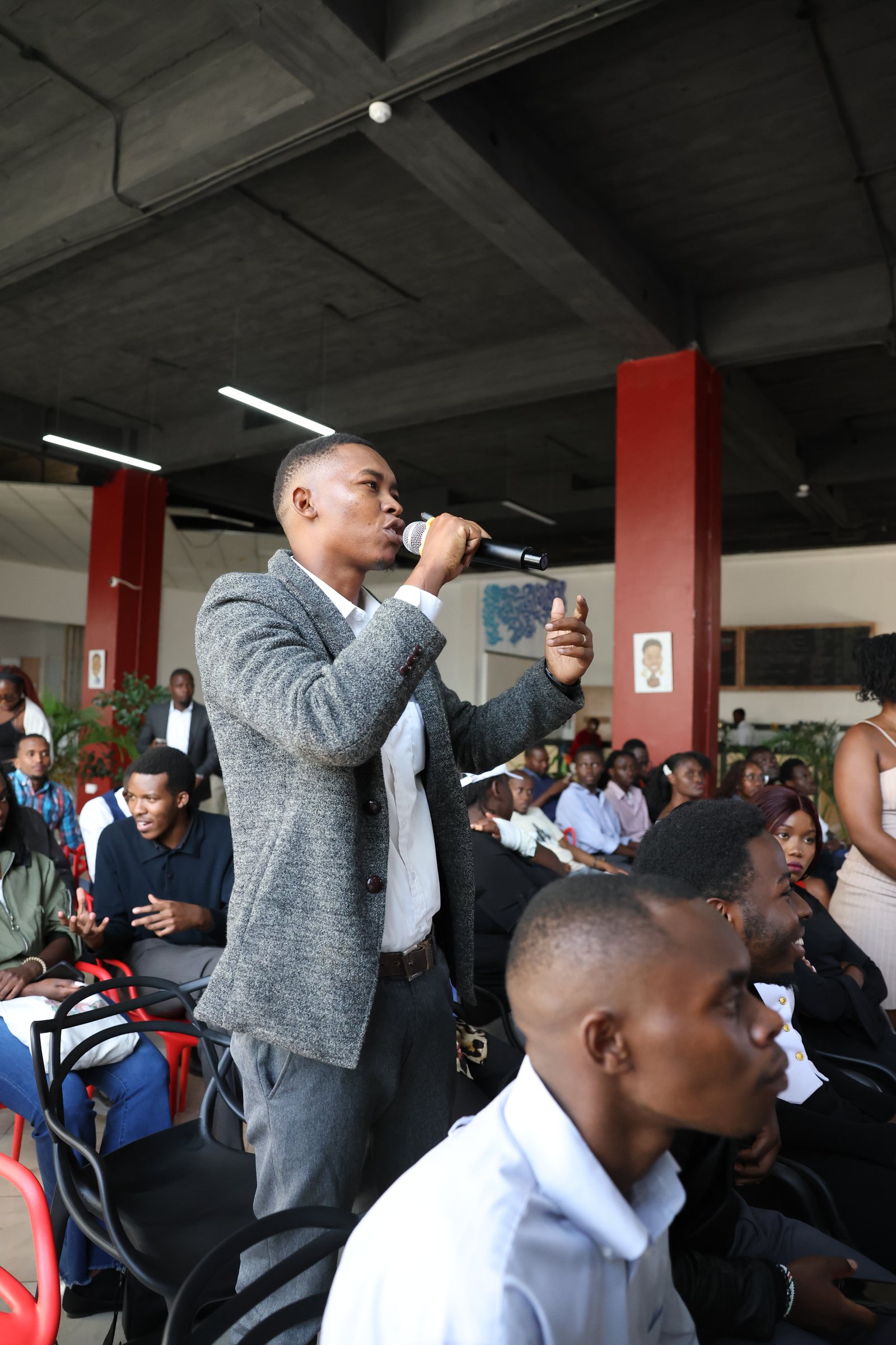 A young participant addressing the forum with a microphone