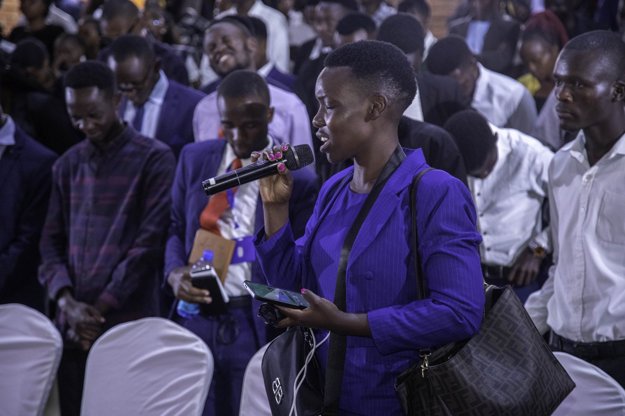 A woman in purple making a contribution from her seat