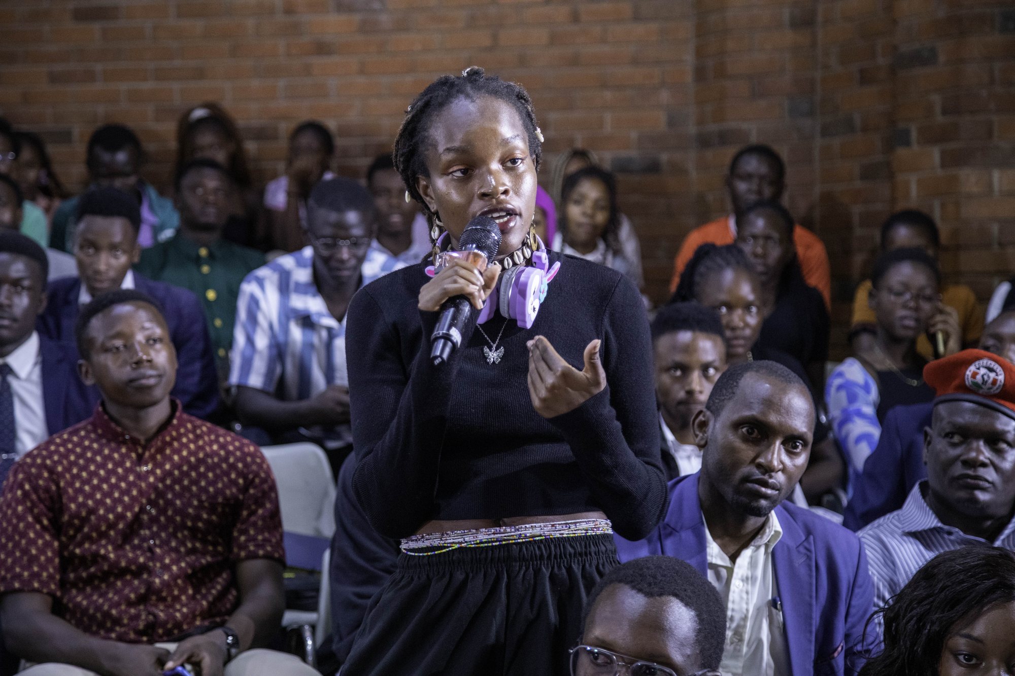 A woman speaking passionately with the audience behind her